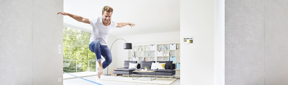 Mann, der in einem Wohnzimmer ist und in die Luft springt.